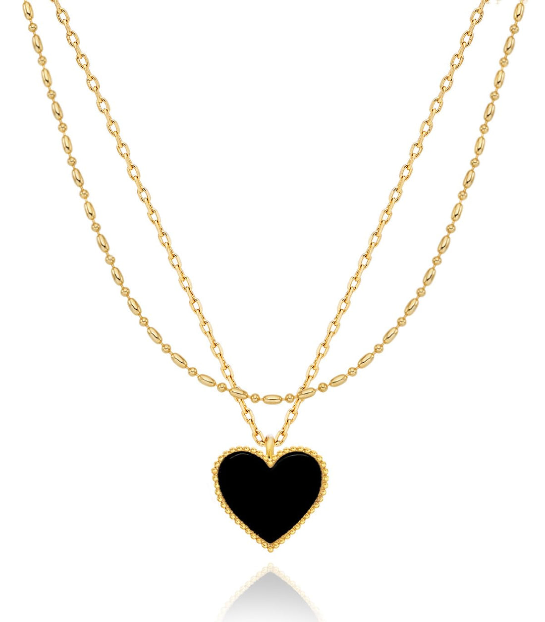 Flat lay of gold layered necklace with onyx black heart pendant and gift box on cream surface