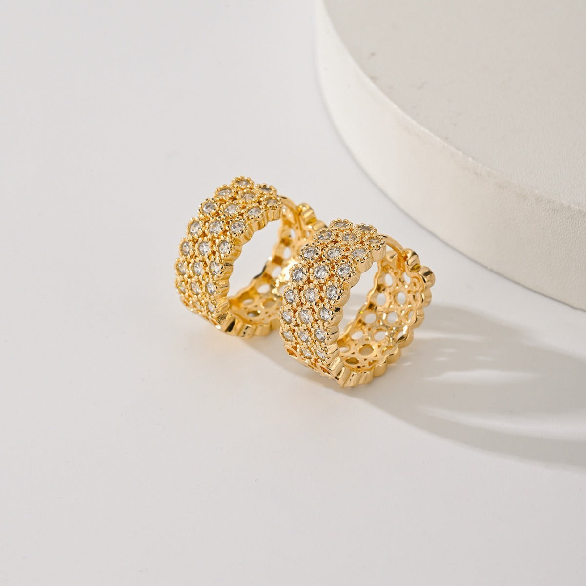Gold-plated pave huggie hoop earrings with three rows of clear stones