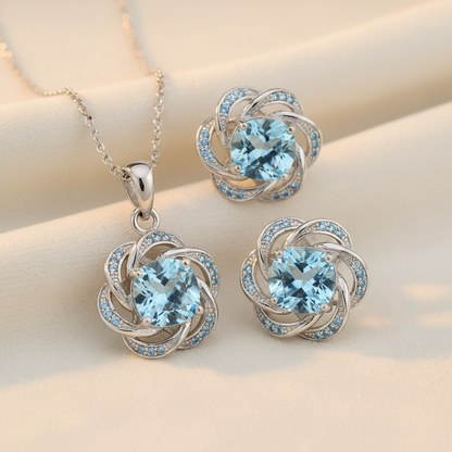 925 sterling silver light blue topaz birthstone necklace and earring set on cream background