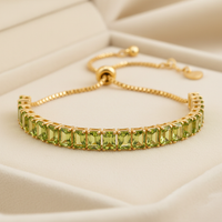14K gold plated August birthstone baguette bracelet with peridot CZ stones on cream background