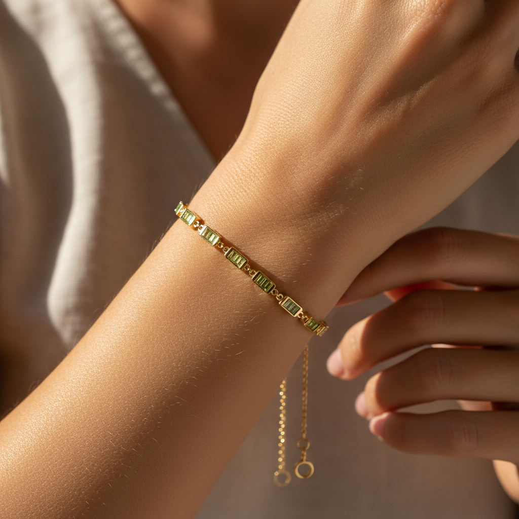 Woman's wrist wearing 14K gold peridot birthstone baguette bracelet