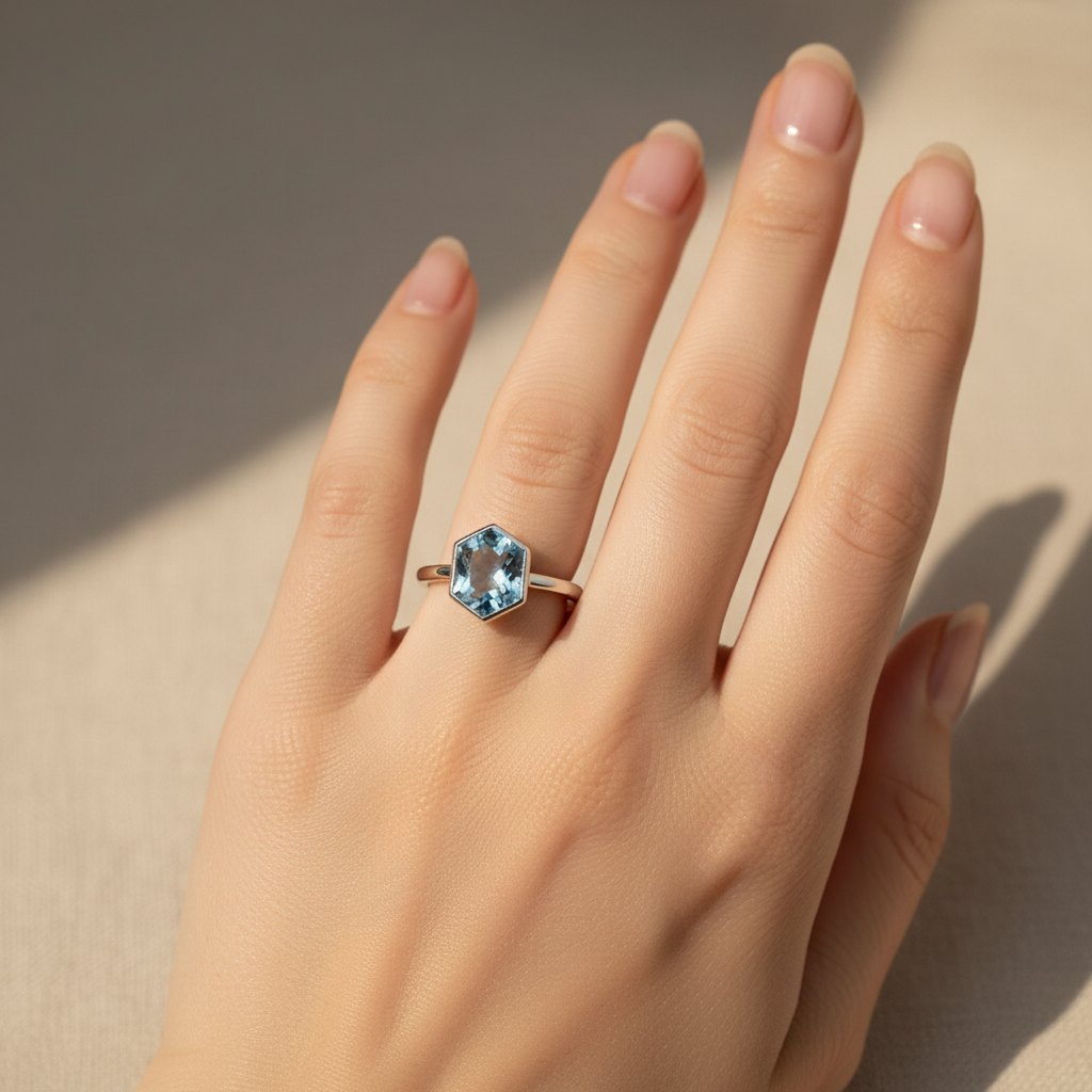 Woman's hand wearing 925 silver natural blue topaz hexagonal ring from above