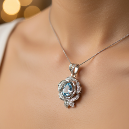 Macro close-up of light blue topaz rose-inspired pendant necklace on woman's collarbone