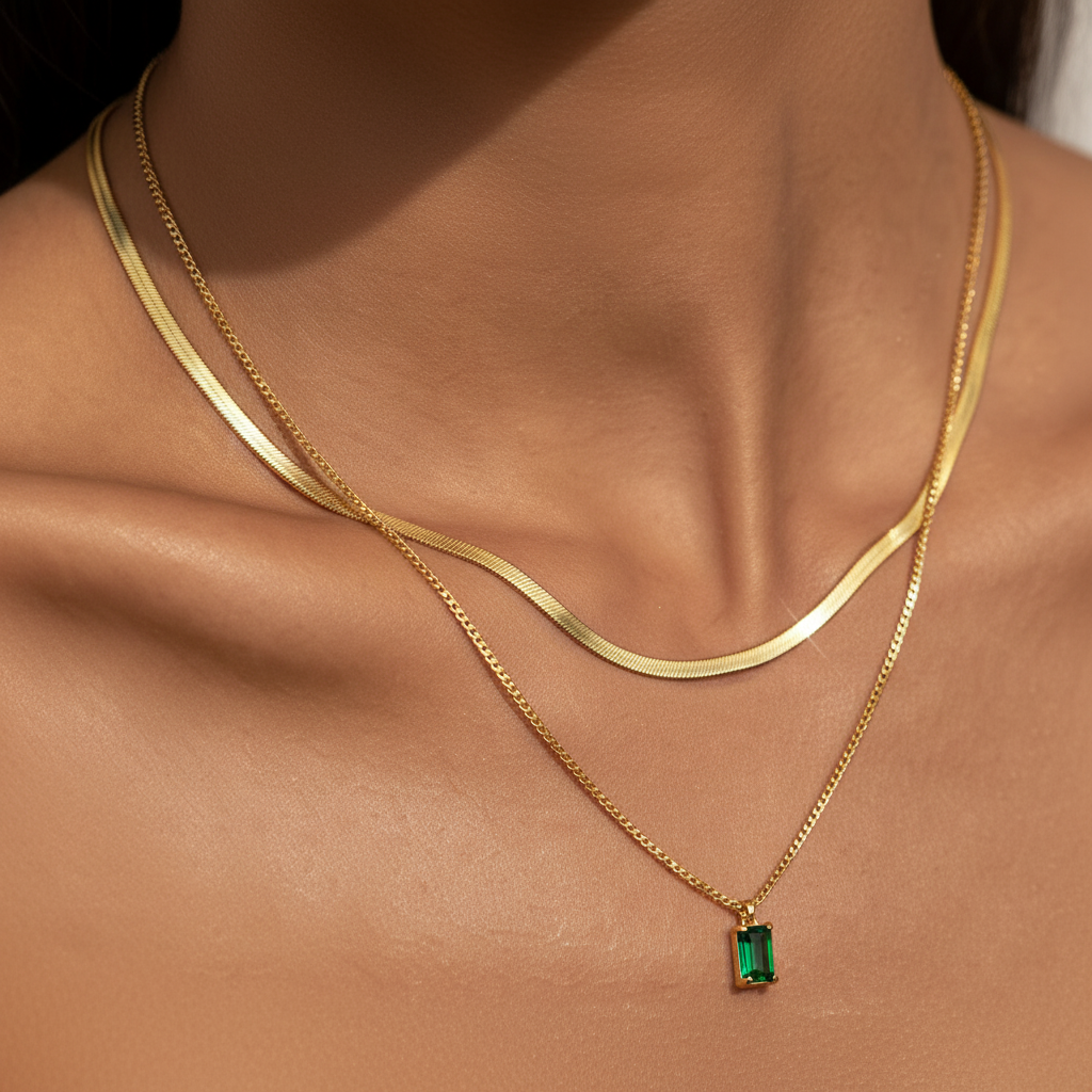 Close-up of May green pendant layered with a snake chain